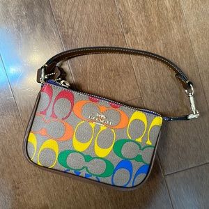 Brand new mini coach bag. Never worn. Multi coloured logo. Brown leather.